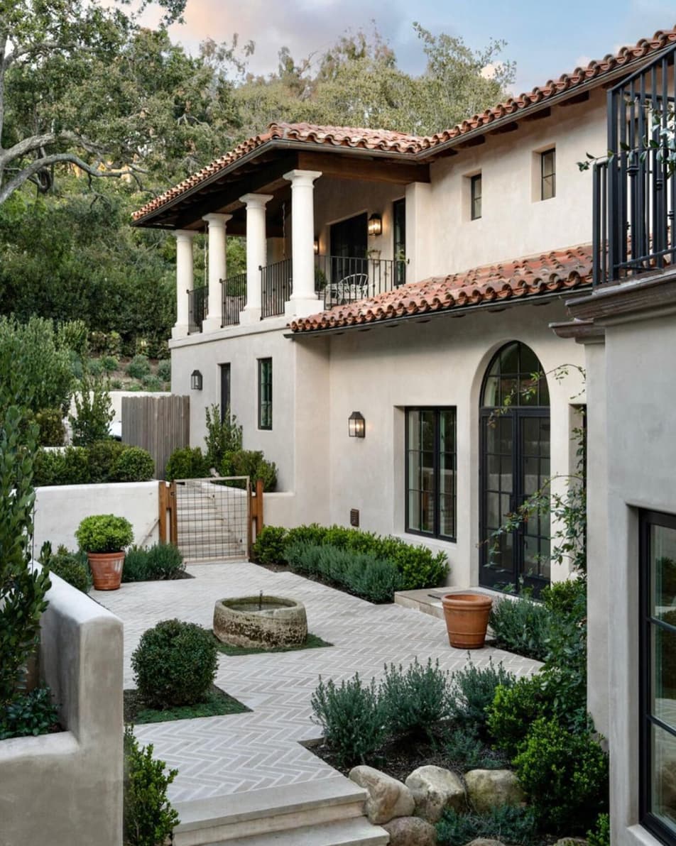 Spanish revival California home with arched entry and herringbone courtyard